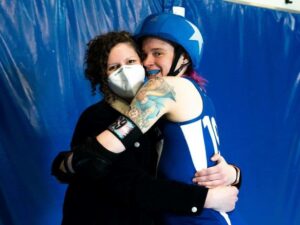Two skaters hugging enthusiastically.