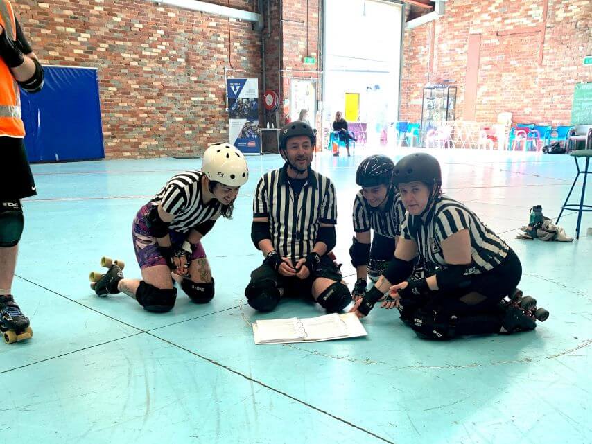 Officials sitting in the middle of the derby track talking rules!